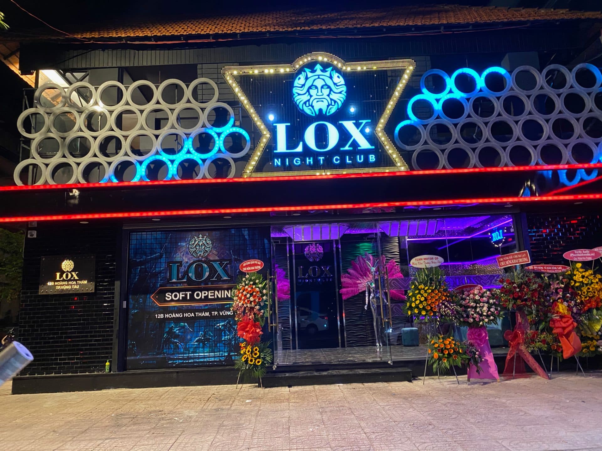 Mặt tiền Lox Night Club về đêm tại 12B Hoàng Hoa Thám, TP. Vũng Tàu, với biển hiệu neon và hoa chúc mừng khai trương.