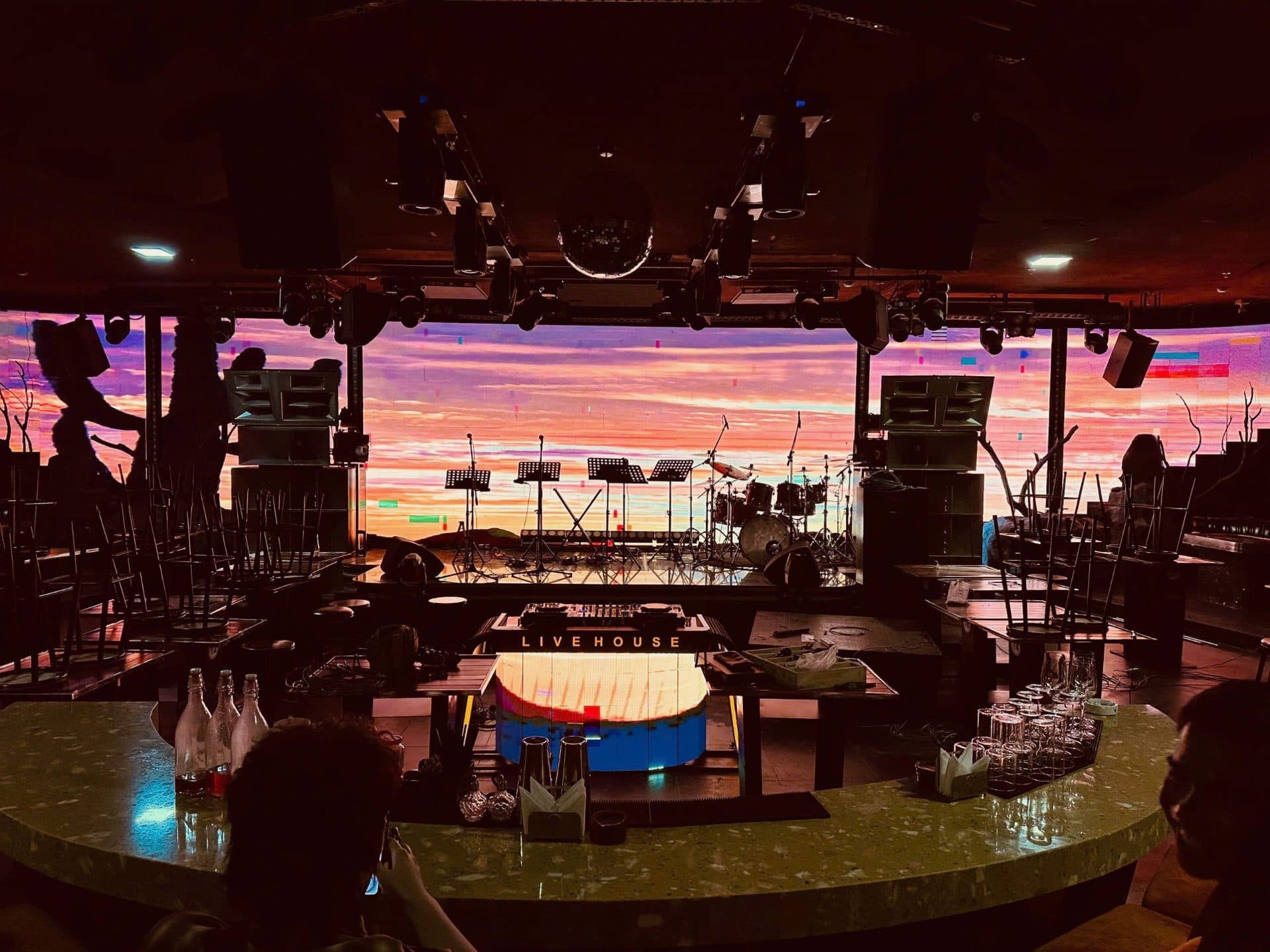 Sân khấu The9 BH Live House với màn hình LED hiệu ứng hoàng hôn, bộ trống và giá nhạc Live Band đã sẵn sàng.