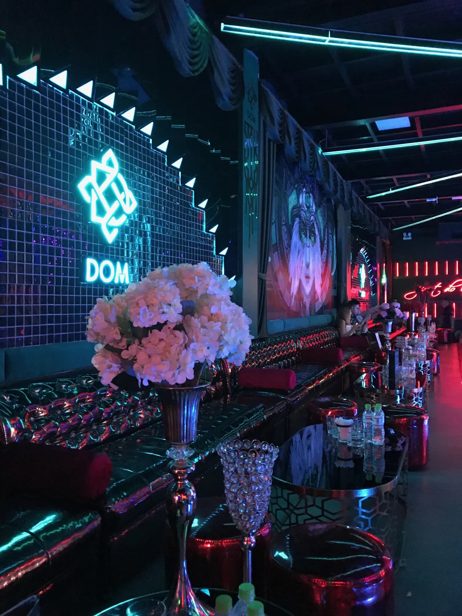 Khu vực quầy/lounge của Dom Club với biểu tượng thương hiệu DOM và tranh trang trí, ghi nhận sau khi hoàn tất thi công.